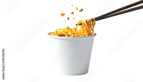 Cup of instant noodles with chopsticks pulling up a serving, toppings falling