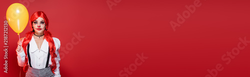 Fotografie Bright red-haired female clown ready for a spooky Halloween party celebration, b