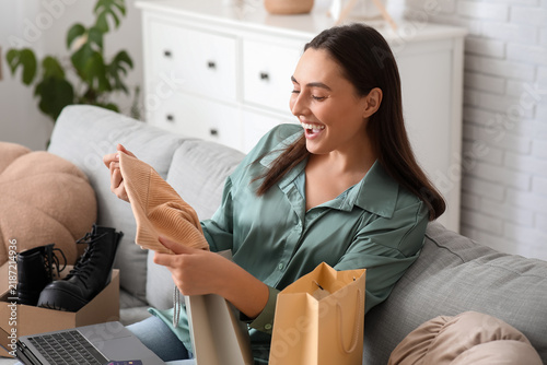 Young woman with laptop and shopping bags at home. Black Friday sale