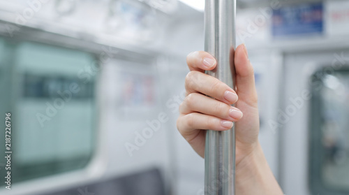 Tapety artystyczne 電車内で手すりをしっかりと掴む女性の手元