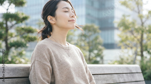 Plakat 屋外で目を閉じて深呼吸しリフレッシュする若い女性