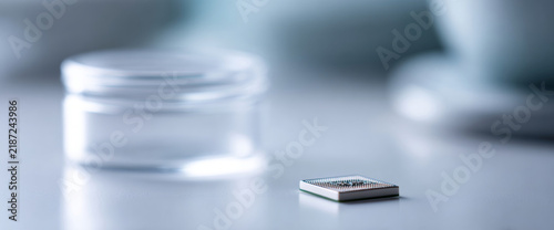 Tapety artystyczne Microchip on white surface with container