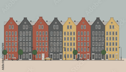 Row of colorful traditional European canal houses in Amsterdam style with parked classic cars on a peaceful city street.
