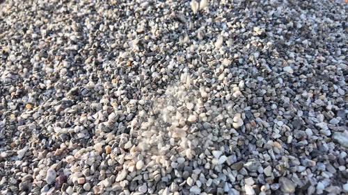crushed stones trickle onto a pile