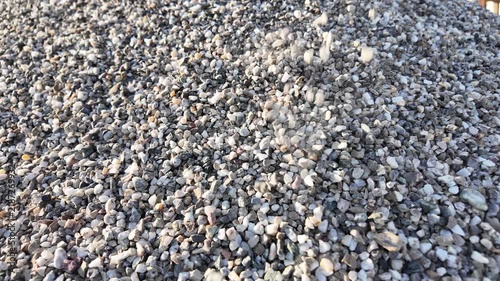crushed stones trickle onto a pile