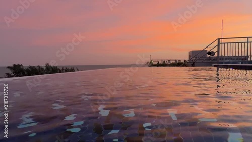 Beautiful infinity edge pool with tropical sea view in the evening

