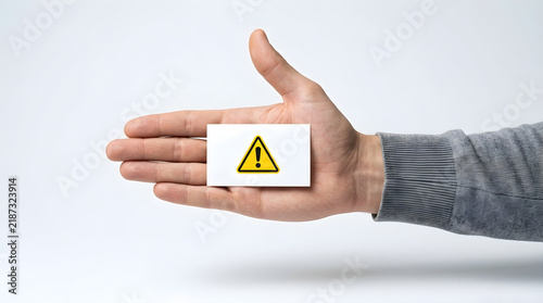 hand holding warning sign card for safety and risk concept
