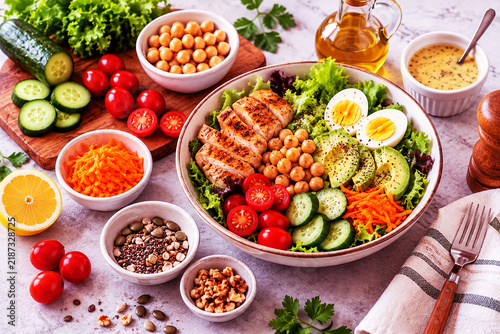 Healthy salad bowl with grilled chicken, chickpeas, avocado, and fresh vegetables