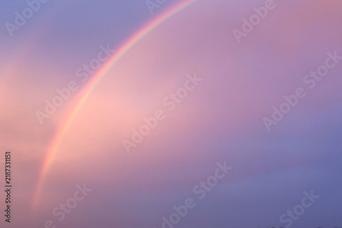 Soft rainbow arcs through twilight sky