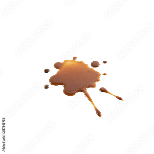 A large splatter of brown liquid caramel sauce with small droplets spread across a white surface isolated on a transparent background