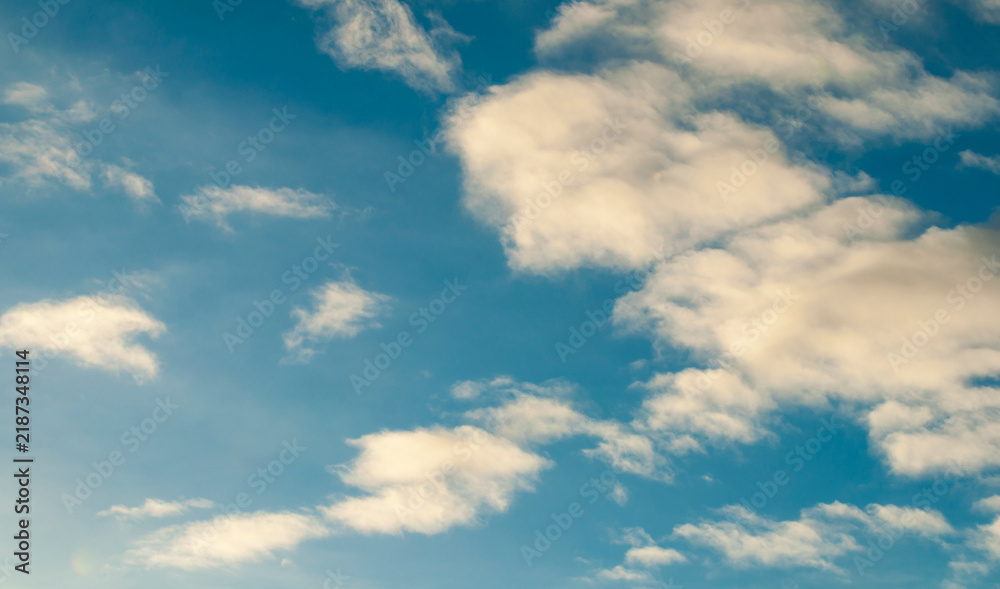 Fototapeta premium Dramatic sunset sky background with scattered white and golden clouds