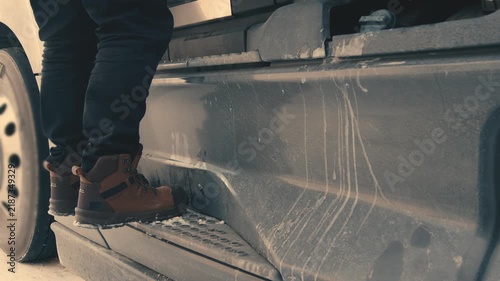 Truck driver climbing down from cabin