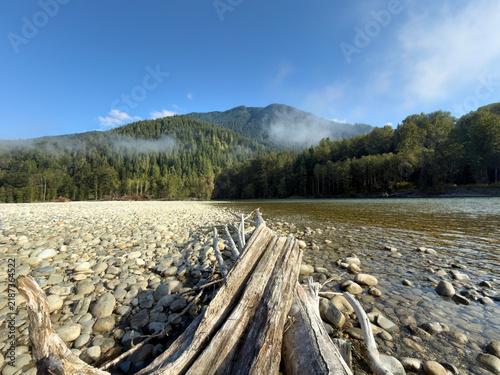 Картината върху платно Light morning fog fading away during sunrise on the Skagit River in summer seaso