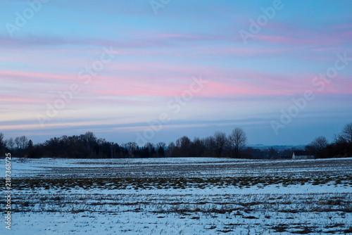 Fotografía Serene winter landscape of a snow-covered field during a gentle twilight sunset