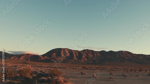 Driving through mojave desert landscape at sunset