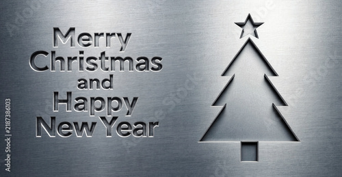 A stylized 3D Christmas tree emblem, cut from a brushed silver metal surface, featuring crisp edges, subtle shading, and a horizontally brushed metallic texture.
