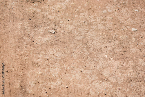 Quadro su tela Close-up of dry cracked earth, sand, and dust texture on a dirt road surface, re