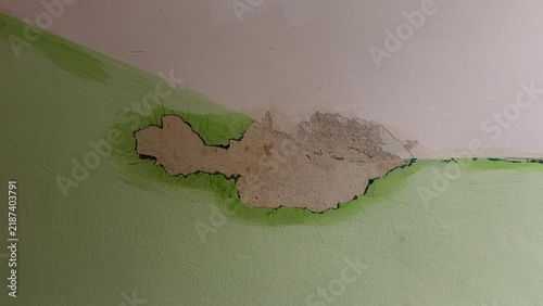 Konstfotografi Close-up of peeling paint and damaged plaster on a green indoor wall caused by water leakage or humidity problems