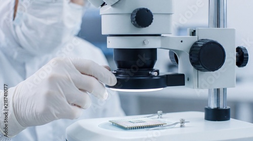 Cleanroom Engineer Inspecting 3D Chiplet Micro-Solder Bumps under Microscope