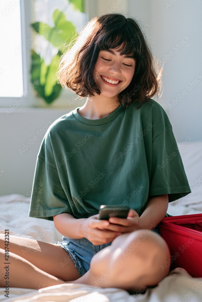 Obraz premium Young woman on bed smiling while using phone for lifestyle banner and social media background with natural light