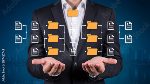 Business hand interacting with virtual screen showing KPI key performance indicators strategy and business icons on dark background.