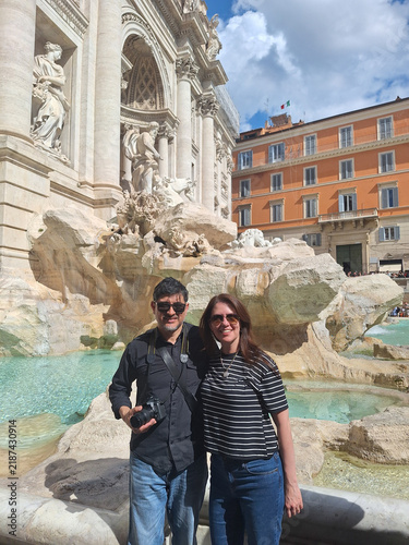 Fotografía Feliz pareja de turistas posando juntos frente a la icónica Fontana di Trevi en Roma, disfrutando de sus vacaciones
