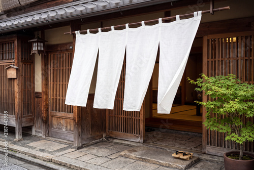 Tapety artystyczne 伝統的な木造の和風店舗の入口に掛かる白い暖簾