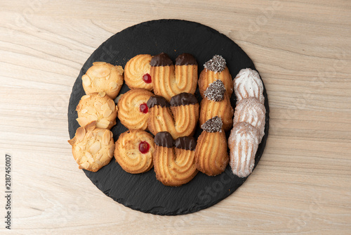 Assorted tea biscuits and cookies on round slate tray