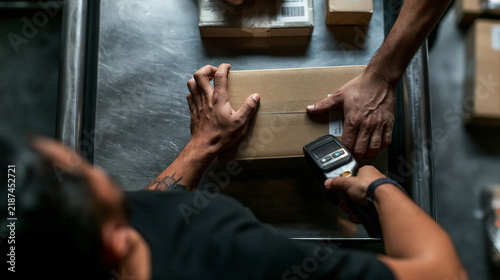Warehouse Worker Scanning Barcode on Cardboard Box Package