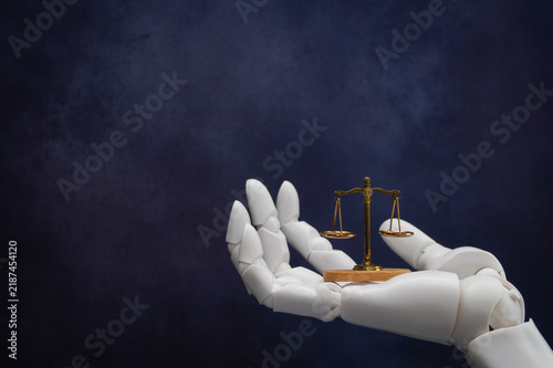 White robotic hand holding a scale of justice. AI in law, legal technology, algorithmic bias, robot ethics concept.