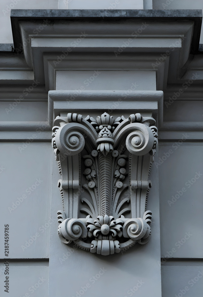 Obraz premium Architecture and classical design, ornate stone capital on a building facade with intricate scrollwork and floral relief details in a historic city