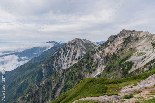 Foto Eroded Alpine Ridge with Scree Gullies Above Distant Peaks, Hakuba, Japan Alps