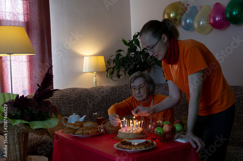 Photography Mother and daughter ignite candles on birthday cake