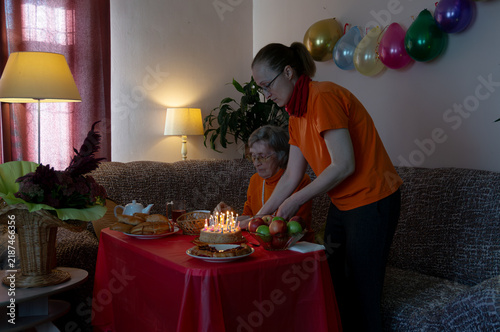 Wall Mural Mother and daughter ignite candles on birthday cake