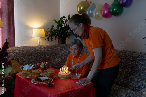 Wall Mural Mother and daughter ignite candles on birthday cake