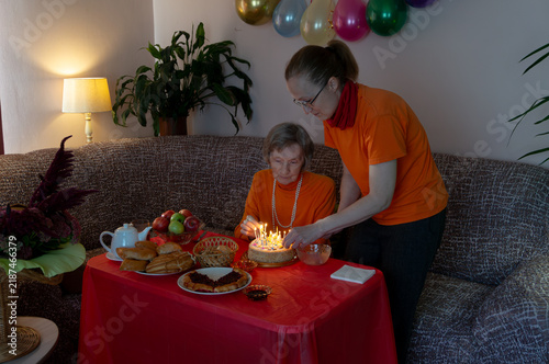 Canvas Print Mother and daughter ignite candles on birthday cake
