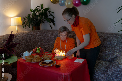 Canvas Print Mother and daughter ignite candles on birthday cake