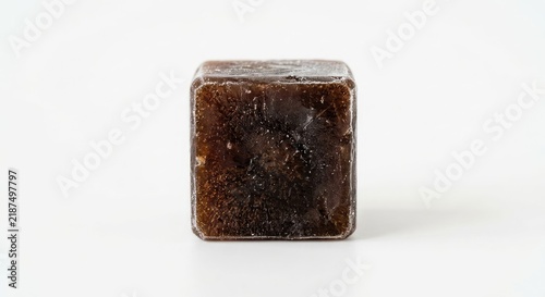 Dark brown translucent resin block on white background.