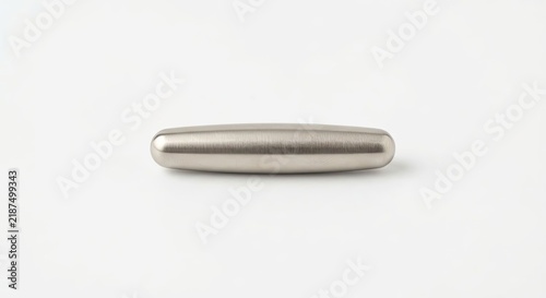 Silver pill shaped magnetic metal cylinder.