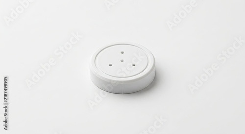 White circular electronic sensor or plastic cap.