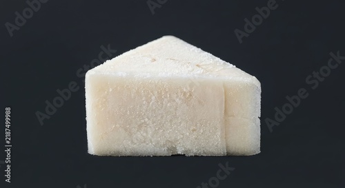 White rectangular crystalline sugar block on dark background.