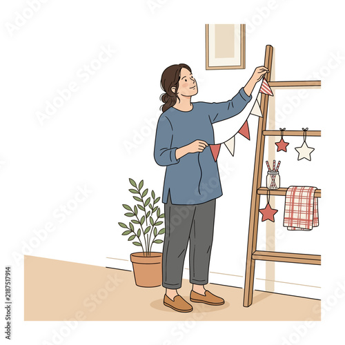 Young Woman Decorating Her Cozy Home Interior with Festive Bunting Banner and Wooden Shelf Accessories