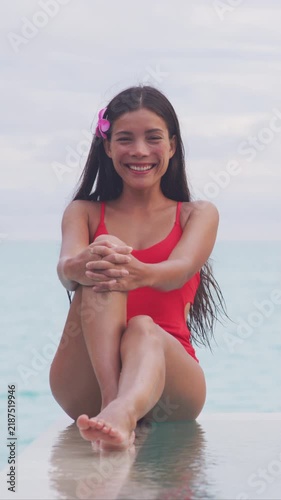 Spa woman after laser treatment with shaved legs. Luxury resort travel vacation natural beauty picture by idyllic overwater bungalow villa. Woman relaxing by infinity pool. Social media influencer