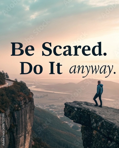 A lone figure stands on the edge of a cliff contemplating the beauty of nature and the courage to face fears embracing the mantra be scared. Do it anyway.