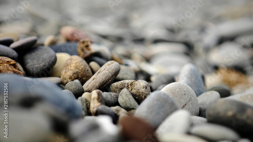Фотография A close-up view of various smooth pebbles on a beach