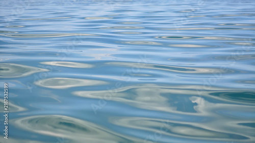 Fotografie Calm blue water surface with gentle ripples and reflections
