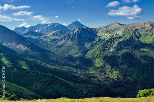 Foto Majestic view of Krivan peak and mountain ridges in High Tatra Mountains, scenic landscape of deep green Jarzabcza Valley with dramatic sunlight and copy space
