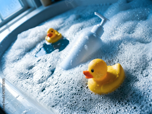 Toy duck and soap dispenser floating in bubbles