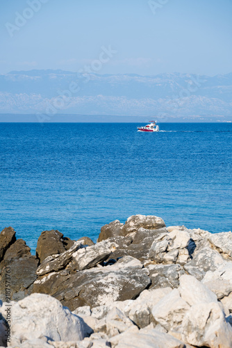 Boats on a turquoise beach on Cres – crystal-clear Adriatic Sea, sandy shore, blue sky, rocky coastline, summer holiday and travel scenery.