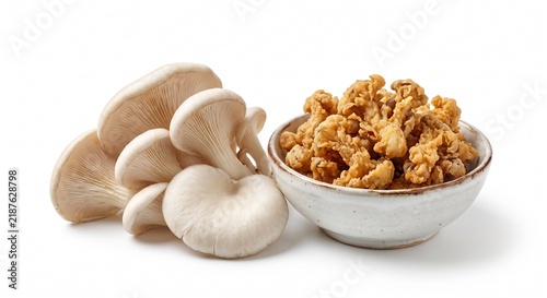 Fresh oyster mushrooms and a bowl of crispy fried mushroom snacks on white background